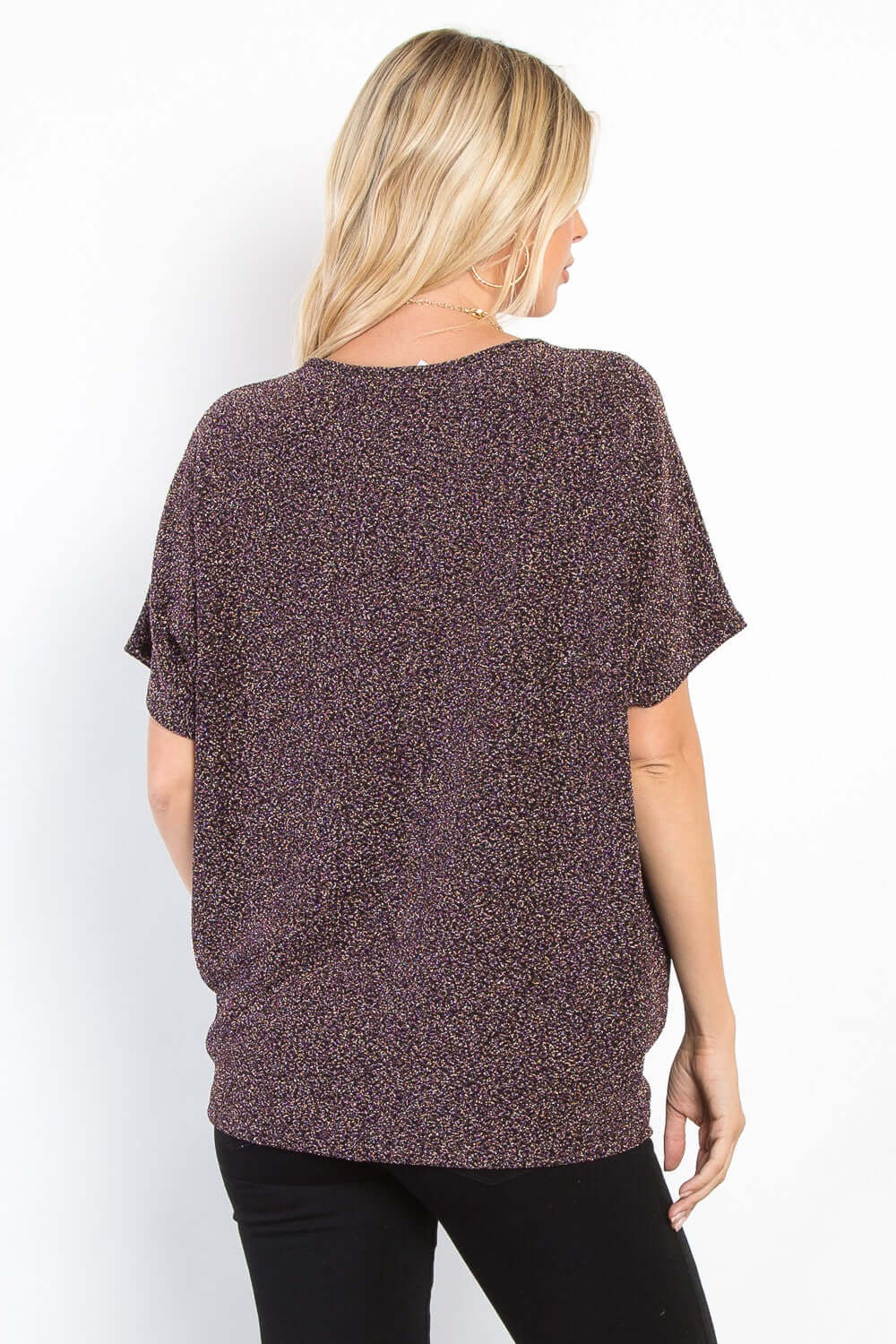 Woman wears full size Lurex knit top with center elastic cinch, showcasing sparkling texture and casual elegance from the back view.