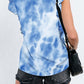 Woman wearing Bella Road Ruffled Printed Round Neck Cap Sleeve T-Shirt in blue pattern, paired with black denim shorts and a black bag.