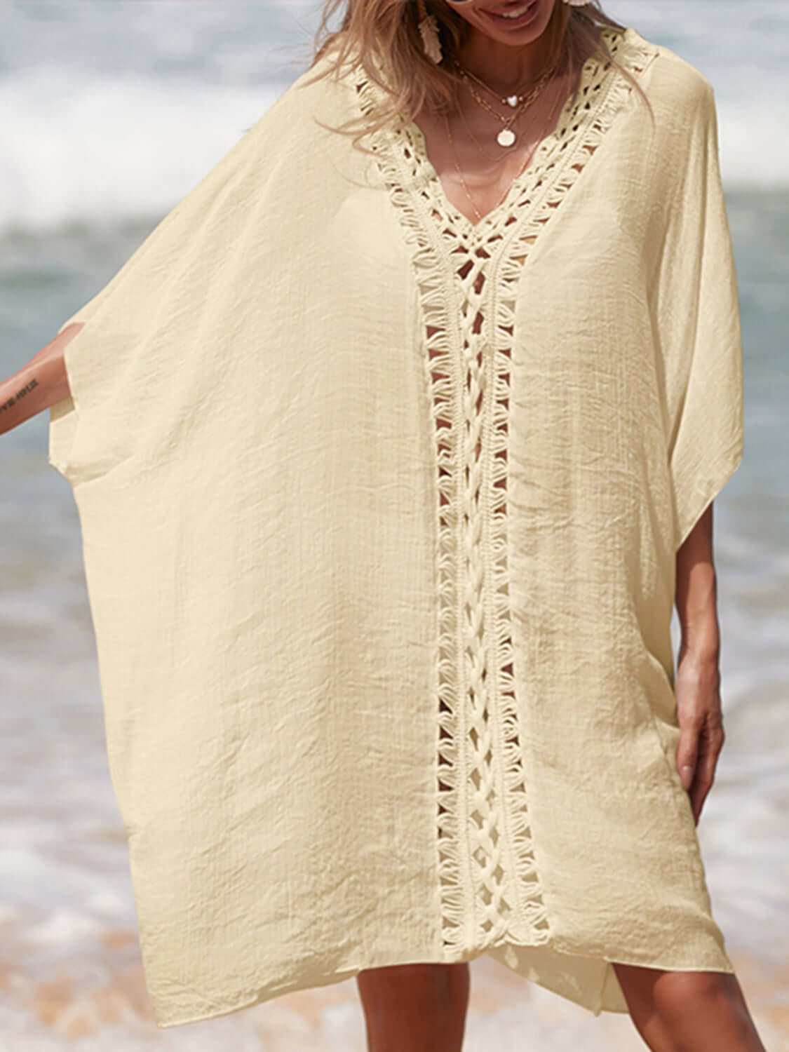 Woman wearing a cutout V-neck three-quarter sleeve sheer cover up at the beach