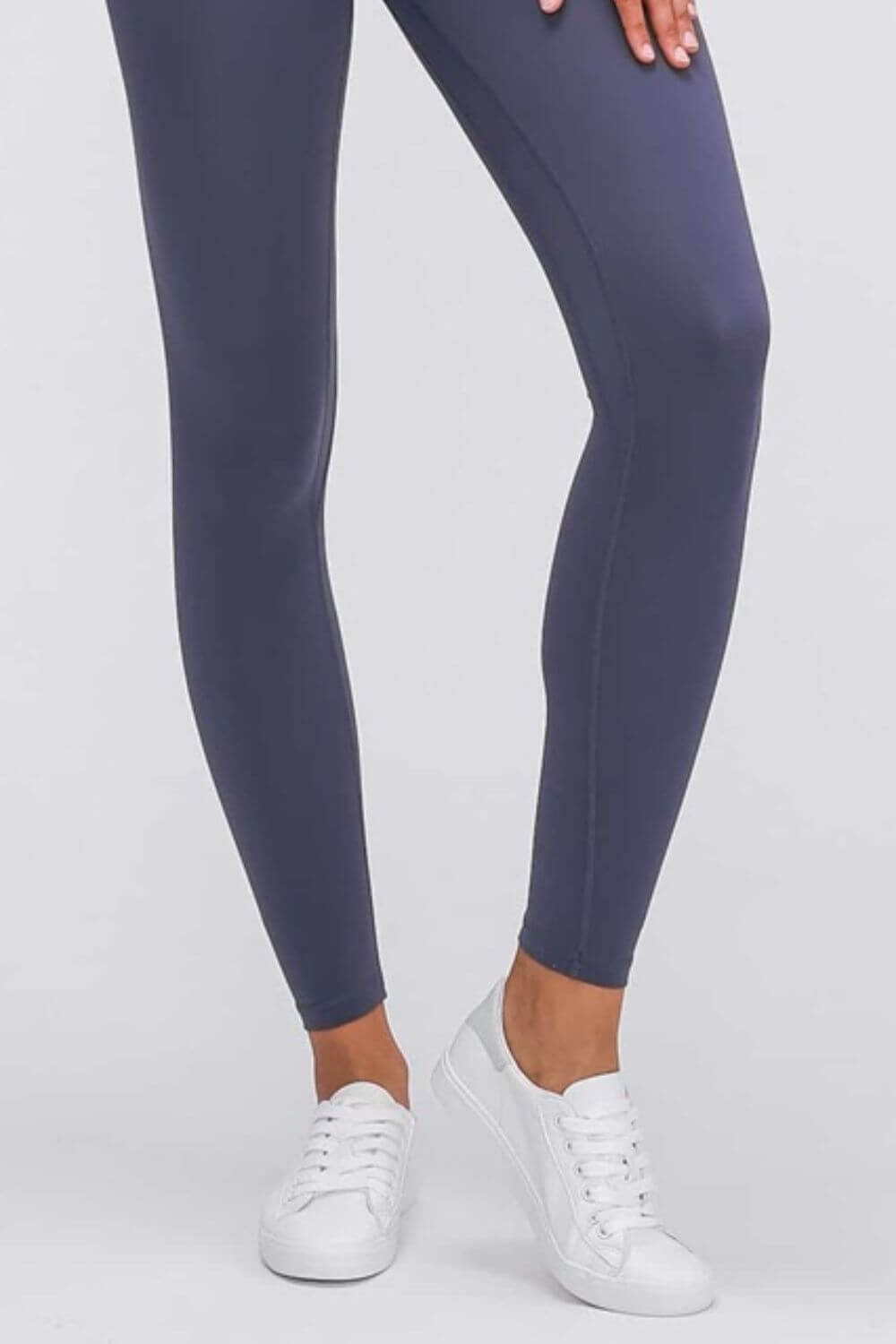 A close-up of Millennia Ultra Soft High Waist Leggings in navy paired with white sneakers, perfect for athleisure styling.