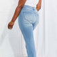 Woman wearing Vibrant MIU Full Size Jess Button Flare Jeans with frayed hem, back view showcasing fit and style