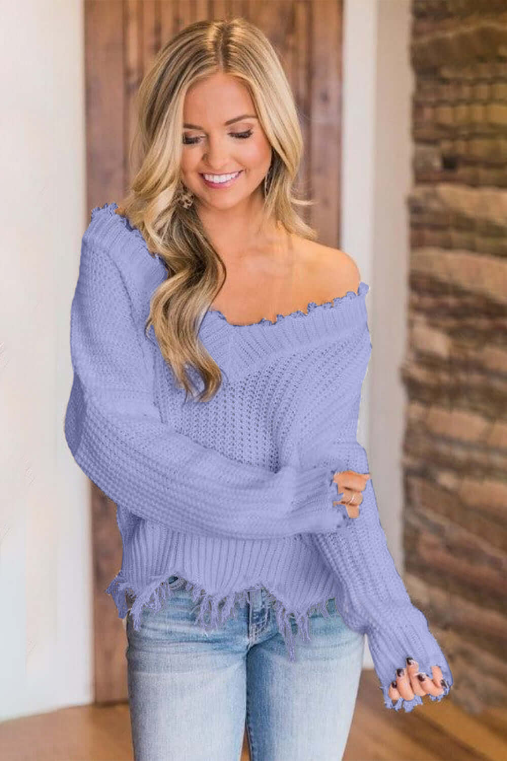 Woman wearing Bella Road frayed hem dropped shoulder sweater in lilac, stylish and playful fashion piece.