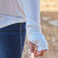 Close-up of a person wearing a slightly stretchy, white Round Neck Long Sleeve T-Shirt with blue jeans, showing the sleeve detail.