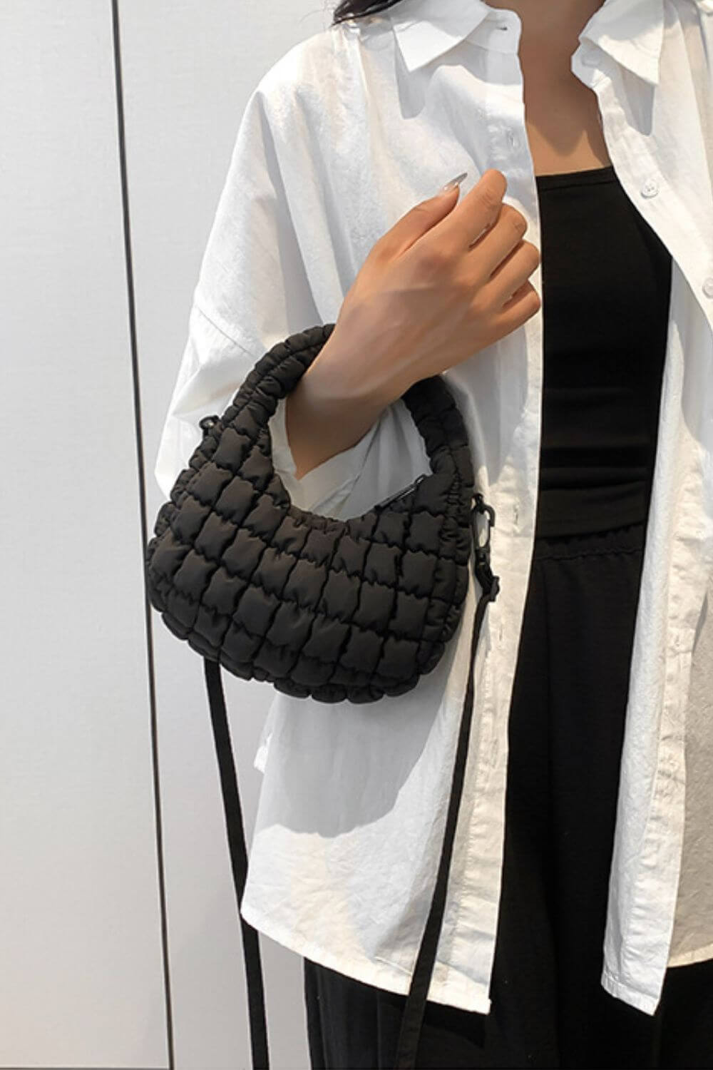 Woman holds Bella Road Quilted Puffy Removable Strap Crossbody Bag in black with a stylish quilted design and versatile strap.