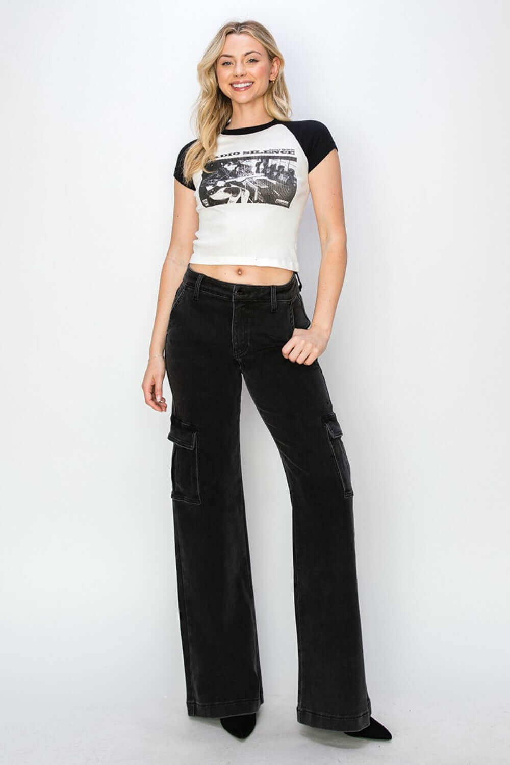 Woman wearing high-rise wide leg cargo jeans paired with a graphic t-shirt, showcasing a trendy urban style with Risen Jeans.