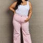 Woman wearing Raelene High Waist Wide Leg Jeans in Light Pink, showcasing Risen Jeans' chic and retro-inspired high-rise fashion.