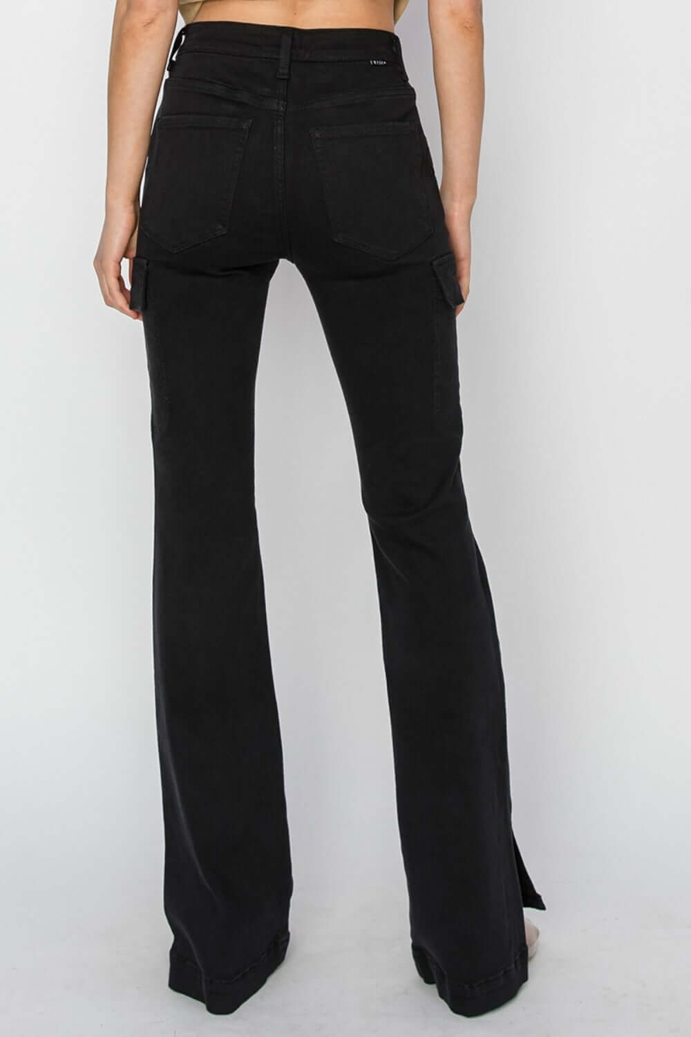 Rear view of high-rise side slit cargo bootcut jeans by Risen Jeans, showcasing trendy design and utilitarian cargo pockets.