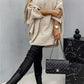 Woman in Bella Road Round Neck Batwing Sleeve Sweater, chic and cozy outfit with quilted black handbag.