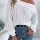 Woman wearing Bella Road Cable-Knit One Shoulder Long Sleeve Sweater in white, paired with blue jeans and a black belt.