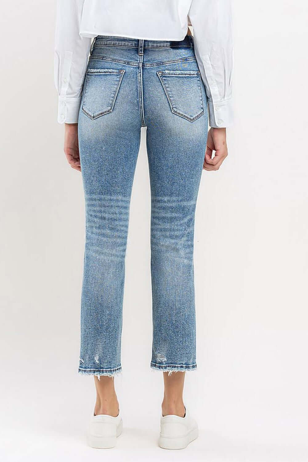 Woman wearing Lovervet Full Size High Rise Slim Straight Jeans, showcasing a flattering high-rise waist and slim straight leg style.