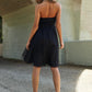 Woman wearing black mesh ruffle tube top swing dress standing under bridge, showcasing stylish and comfortable summer fashion.