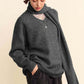 Stylish model in a charcoal V-neck sweater with scarf, showcasing a relaxed fit and chic comfort. Perfect for any occasion.