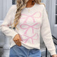 Woman wearing Angel Wings Bow Graphic Round Neck Long Sleeve Sweater in white with pink bows, paired with a denim skirt.