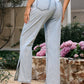 Stylish woman wearing Bella Road Side Slit Straight Leg Jeans with pockets, showcasing the back and side slit detail in a floral garden.