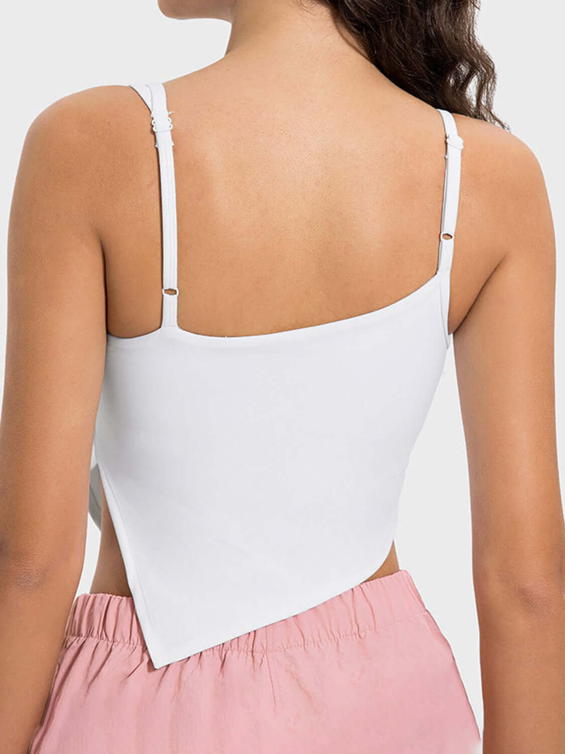 Back view of Millennia Slit Asymmetrical Neck Active Cami in white, showcasing its stylish slit detail and adjustable straps.