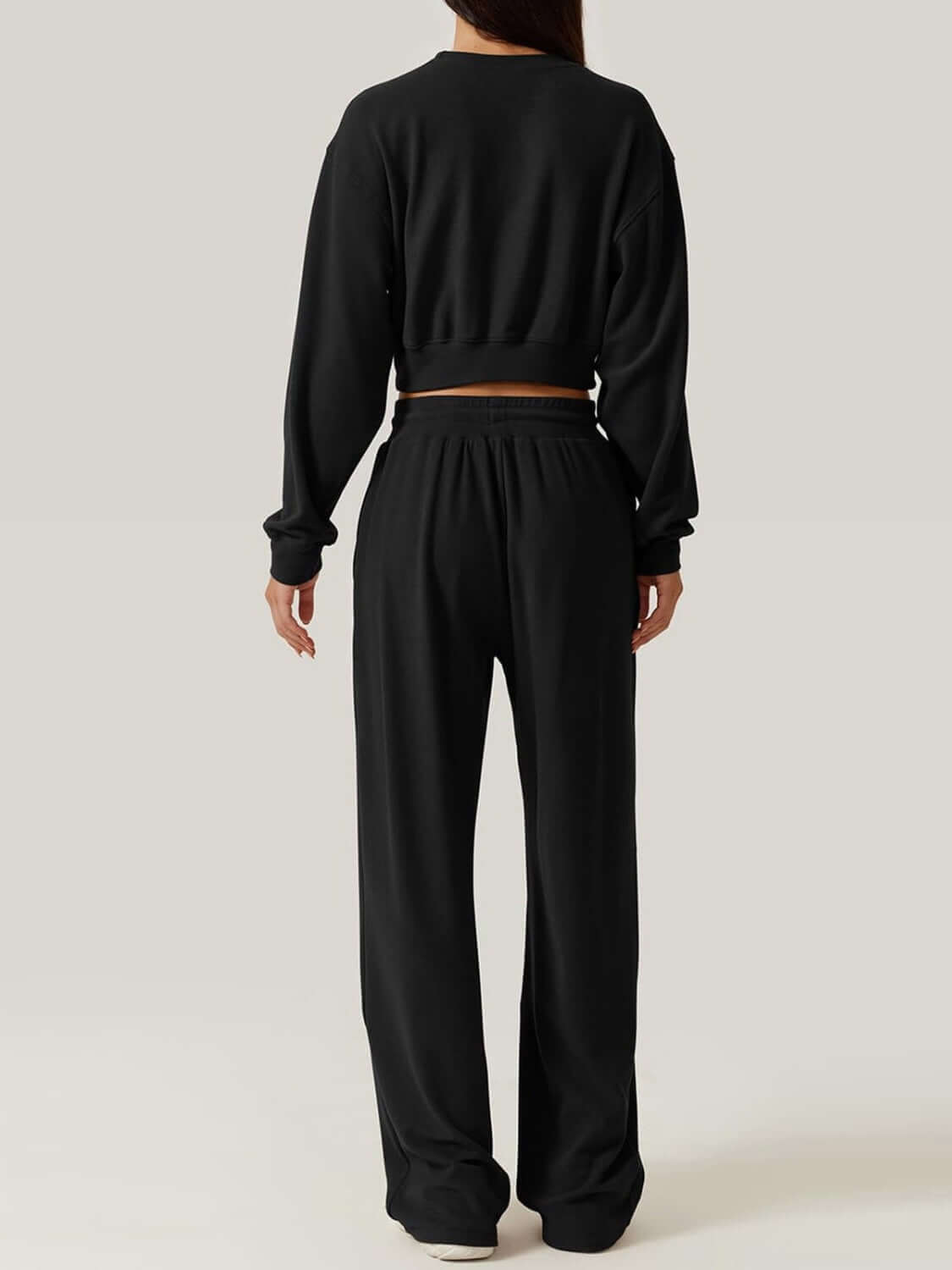 Back view of Bella Road Crisscross Round Neck Top and Drawstring Pants Set in black, illustrating comfortable fit and stylish design.