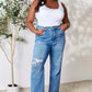 Woman wearing High Waist Distressed Judy Blue Jeans, full-size, paired with a white tank top, showing trendy classic comfort and fit.