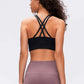 Model showcasing the back of the Millennia Double X Sports Bra with stylish double X strappy design in black.