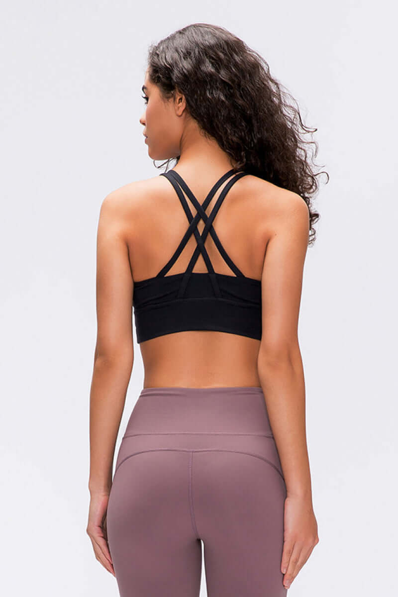 Model showcasing the back of the Millennia Double X Sports Bra with stylish double X strappy design in black.