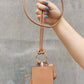 Woman holding Nicole Lee USA vegan leather 3-piece lanyard set with AirPods case