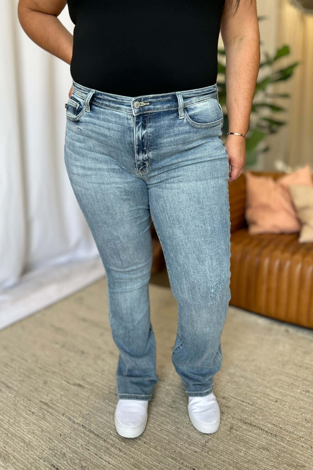 Woman wearing Judy Blue full-size medium rise bootcut jeans, showing comfortable fit and classic style in a casual setting.