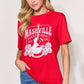 Woman wearing red graphic round neck short sleeve t-shirt with "Nashville Country Music" print.