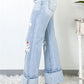 Distressed high waist jeans with pockets, side view. Light wash denim with slight stretch, perfect for a trendy casual look.