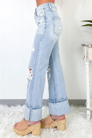 Distressed high waist jeans with pockets, side view. Light wash denim with slight stretch, perfect for a trendy casual look.