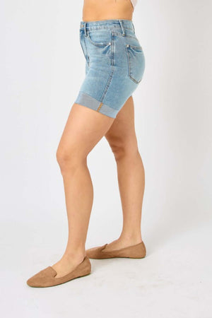 Woman wearing tummy control denim shorts by Judy Blue Jeans, showcasing side view and flattering fit.