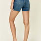 Back view of woman wearing Tummy Control High Waist Denim Shorts by Judy Blue Jeans, showcasing midsection support and stylish comfort.