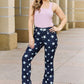 Woman wearing Janelle Full Size High Waist Star Print Flare Judy Blue Jeans in dark wash, standing outdoors in a stylish outfit.