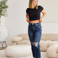 Woman wearing Crop Dylan Full Size Tummy Control Distressed High Waist Raw Hem RFM Jeans standing in stylish room