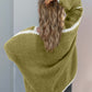 Woman in green open front cardigan with dropped shoulders, showcasing stylish comfort and texture from behind.