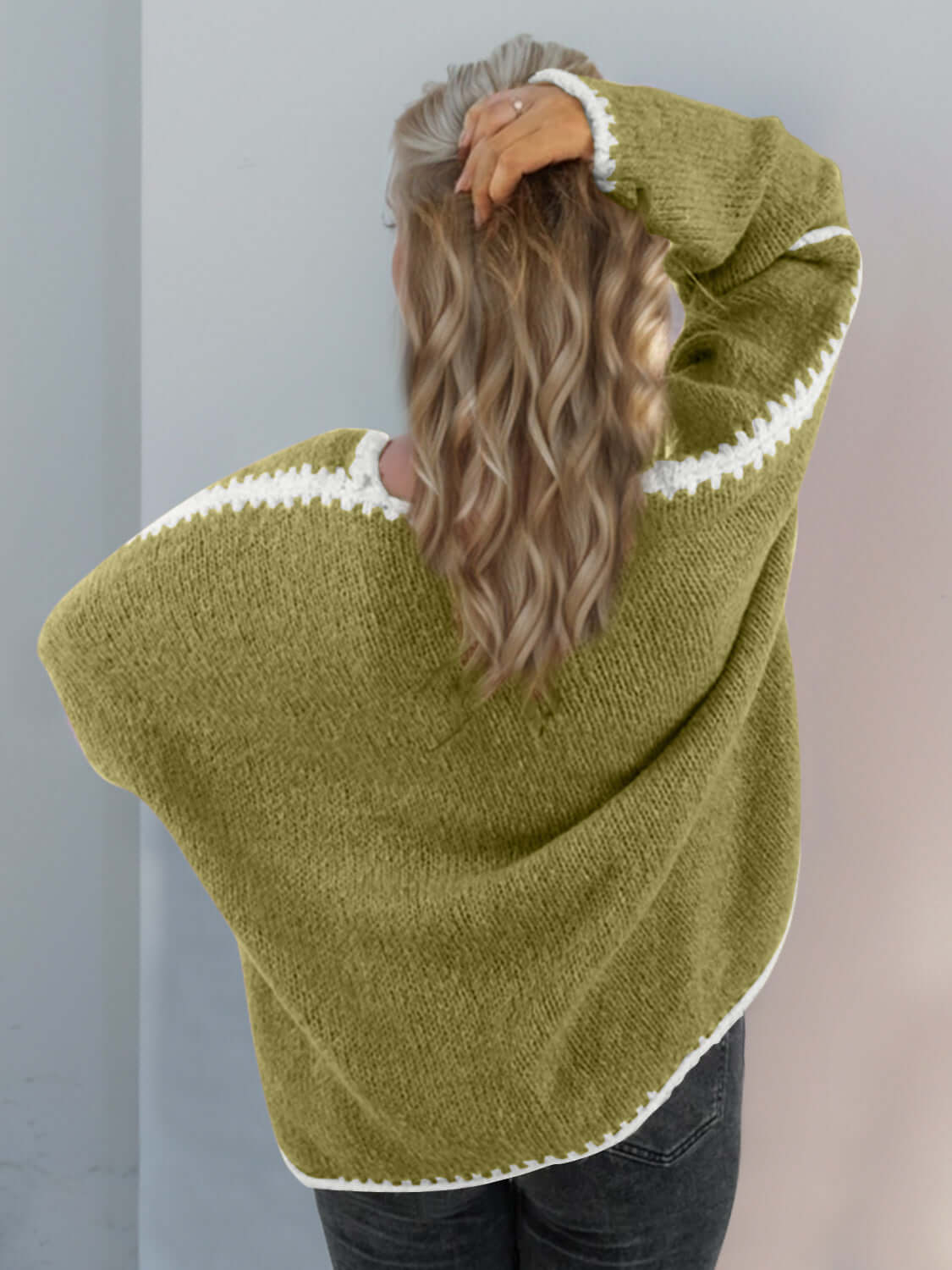 Woman in green open front cardigan with dropped shoulders, showcasing stylish comfort and texture from behind.