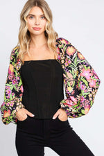 Woman wearing Floral Balloon Sleeve Blouse with elegant floral print and dramatic balloon sleeves, showcasing trendy and feminine style.