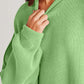 Double Take Side Slit Round Neck Long Sleeve Sweater in green material close-up showing cozy stretch fabric and playful design.