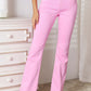 High rise bootcut jeans in pink paired with white sandals and a white top for a stylish look