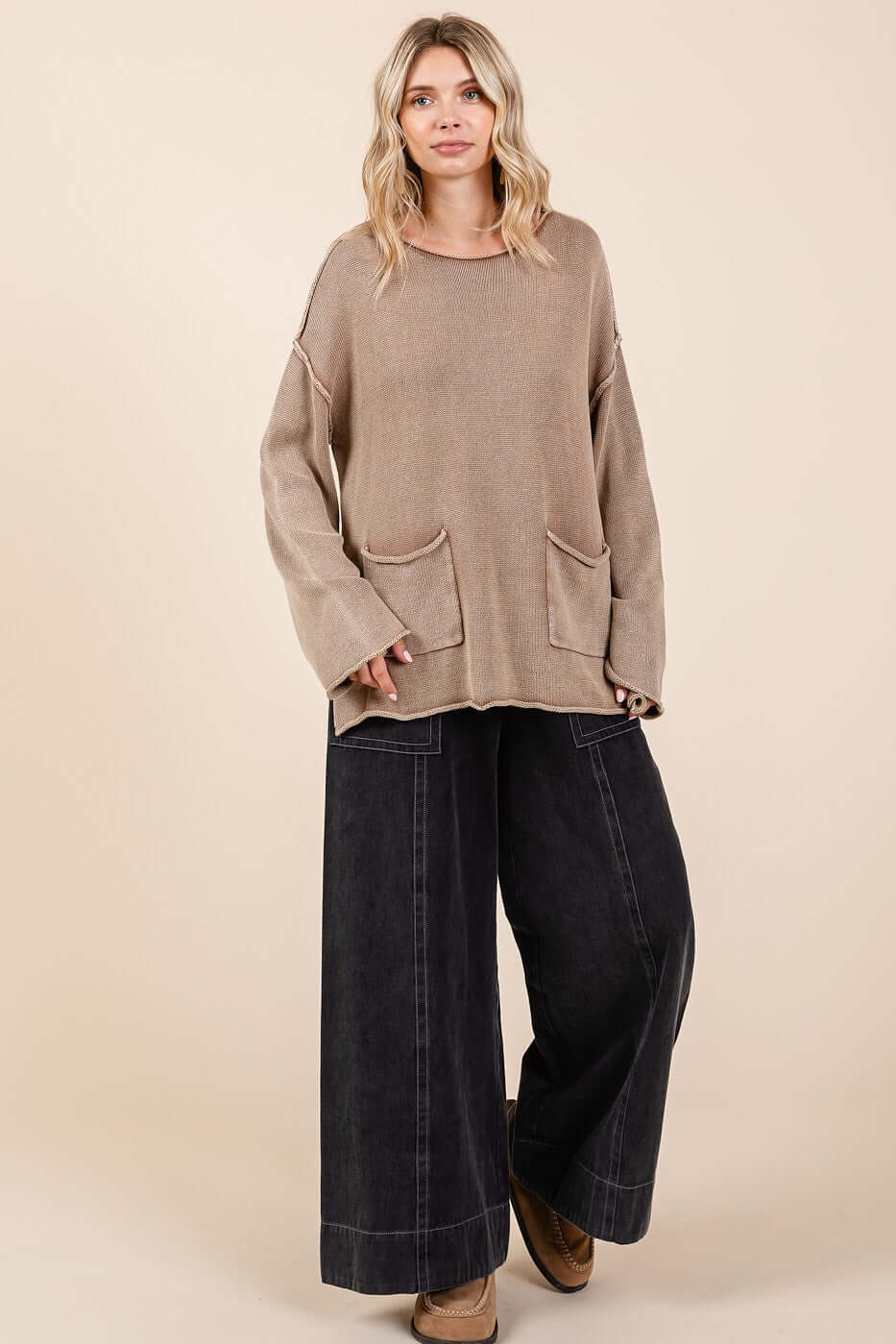 Mineral wash sweater with patch pockets and cut edges, worn with wide-leg jeans for a trendy casual look.