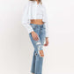 Woman wearing Lovervet Full Size High Rise Slim Straight Jeans with white cropped top and jacket.