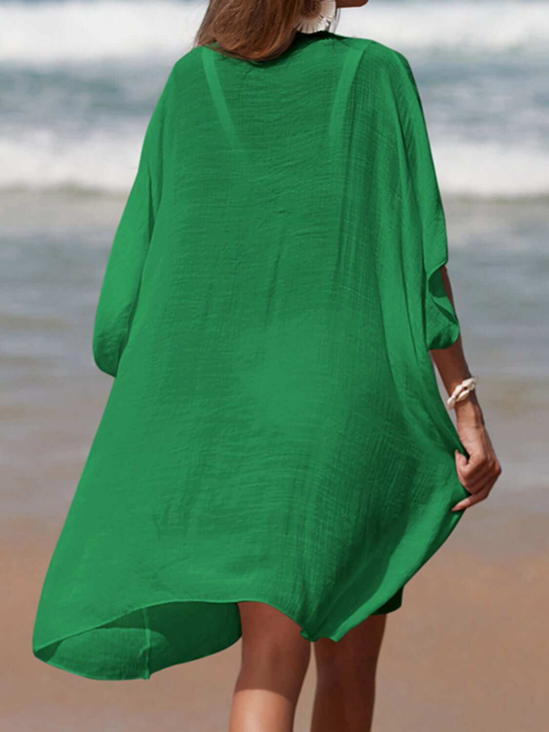 Woman wearing a green Cutout V-Neck Three-Quarter Sleeve Cover Up on a beach