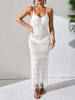 Woman wearing white openwork scoop neck cover-up dress with tassel details and semi-sheer texture standing against light background.