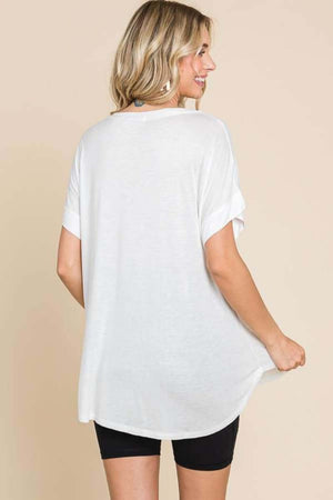 Woman wearing a versatile white round neck short sleeve t-shirt, showing the back view of the relaxed fit design.