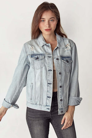 Woman wearing Risen Jeans distressed button-up jacket with frayed detailing and classic style for a modern urban look.