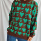 "Bella Road Heart Contrast Long Sleeve Dropped Shoulder Sweater in green and brown worn with blue jeans"