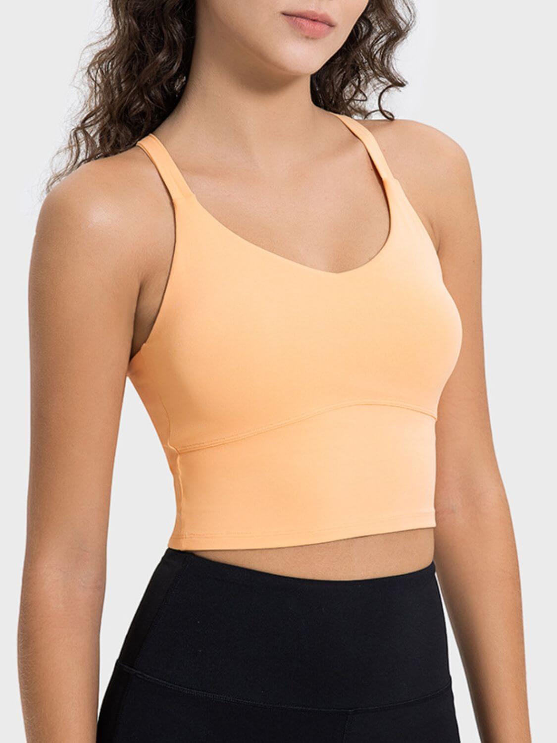 Model wearing a lightweight orange active tank top with a sleek design, perfect for workouts and casual wear.