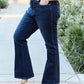 Woman wearing slim bootcut jeans in dark wash with classic comfort and modern style, standing on sidewalk outdoors.