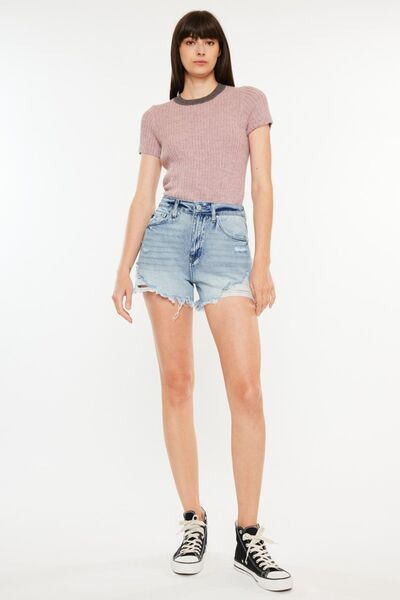 Model showcasing Kancan distressed high waist denim shorts with pockets and a stylish top.