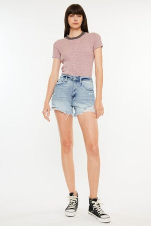 Model showcasing Kancan distressed high waist denim shorts with pockets and a stylish top.