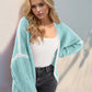 Woman wearing Tiffany Blue contrast open front cardigan with dropped shoulders. Trendy and chic for a stylish look.