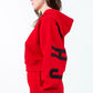 Side view of a woman wearing a red 'Chicago' graphic cropped hoodie with a drawstring and pocket, showcasing a trendy street style.